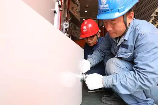 工作人员在35千伏郭家湾变电站查看过渡柜开关设备