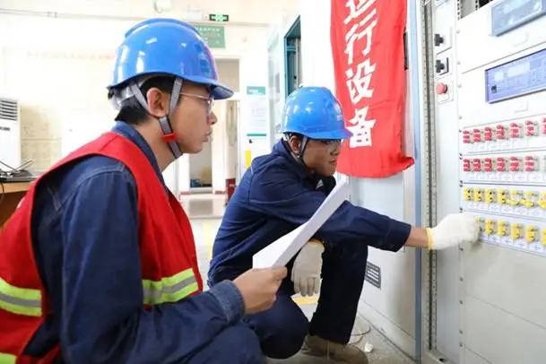 工作人员在35千伏郭家湾变电站核对保护测控装置设备