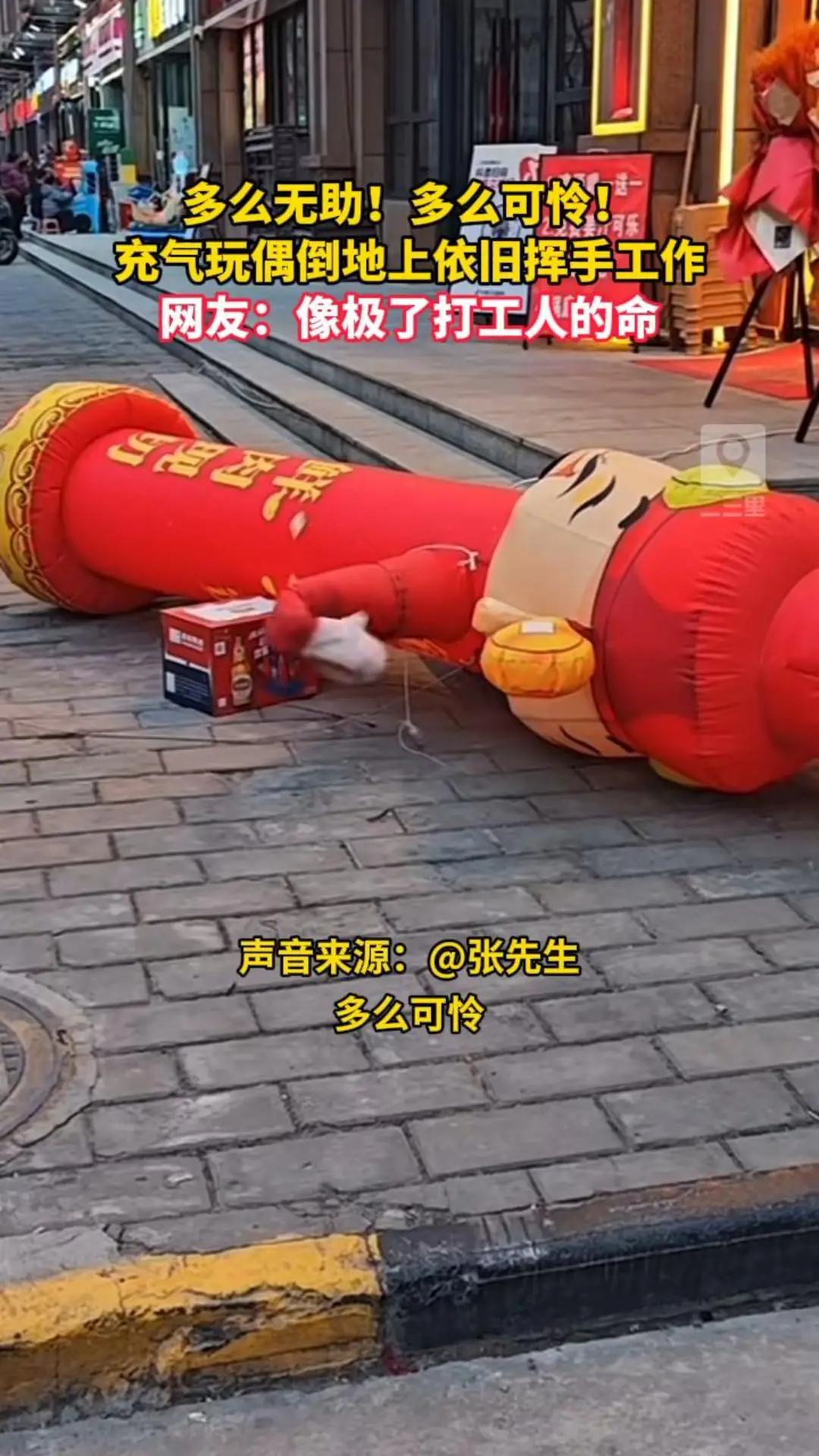 多么无助！多么可怜！ 充气玩偶倒地上依旧挥手工作 网友：像极了打工人的命