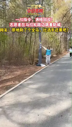 长春马拉松医疗点志愿者在路边热情蹦跳为参赛者加油助威。