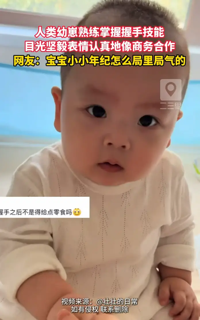 宝宝刚学会握手表情认真得像签合同，逗得妈妈哈哈大笑。